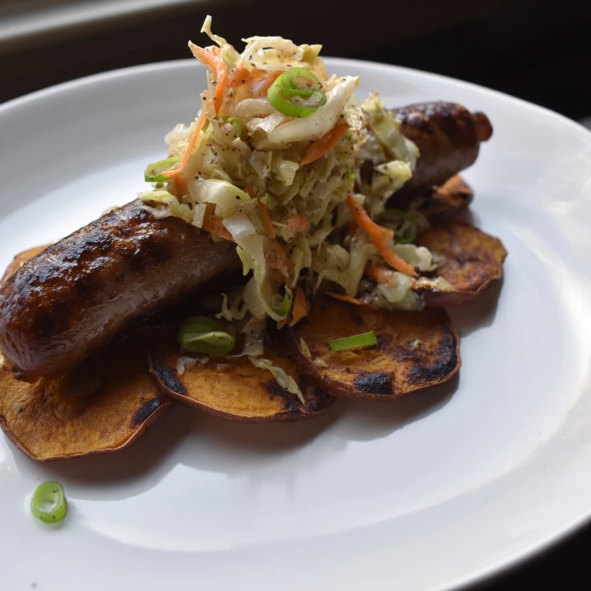 Golden-brown baked Sweet Potato Bratwursts with vibrant sauerkraut slaw; a comforting German-American meal.