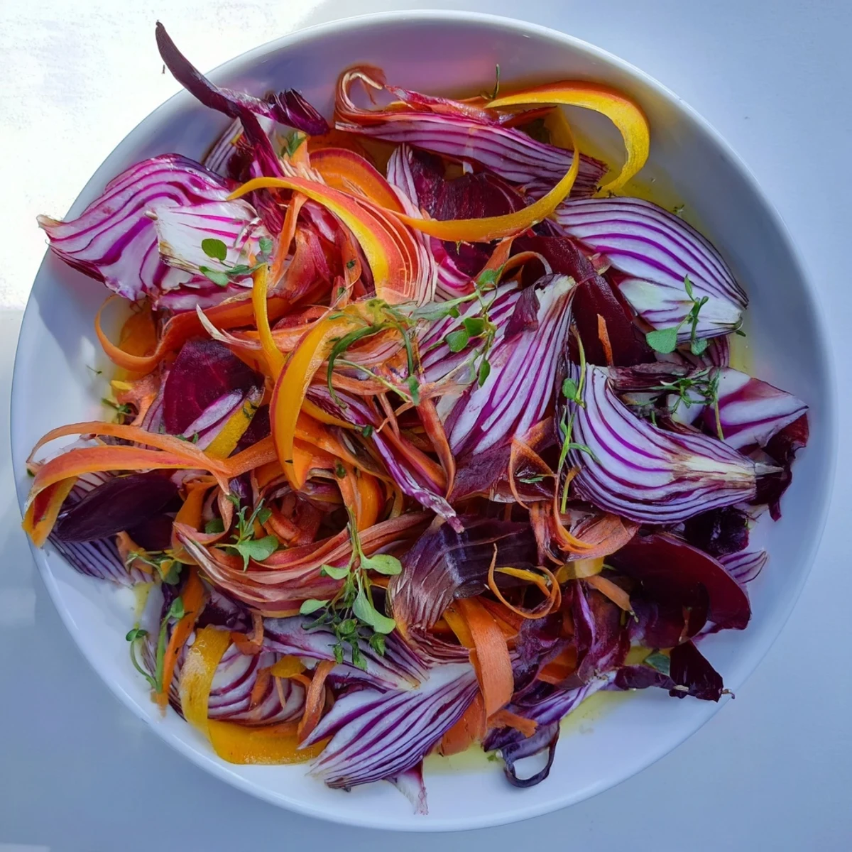 Fresh and vibrant "Spinning Top" salad with colorful shaved vegetables and herbs, ready to serve.