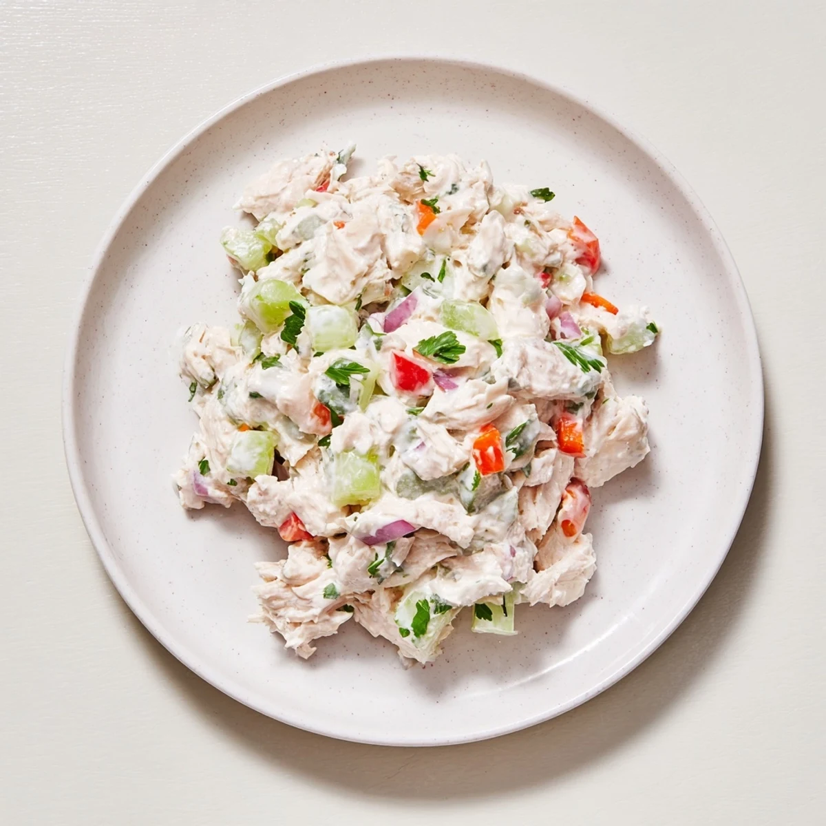 Creamy canned chicken salad with vibrant red peppers, ready to serve on a plate.