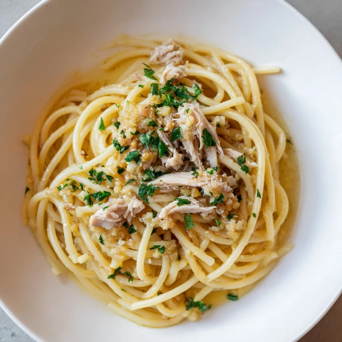 Golden-brown Simple Garlic Butter Bucatini, served with tender chicken and fresh parsley.