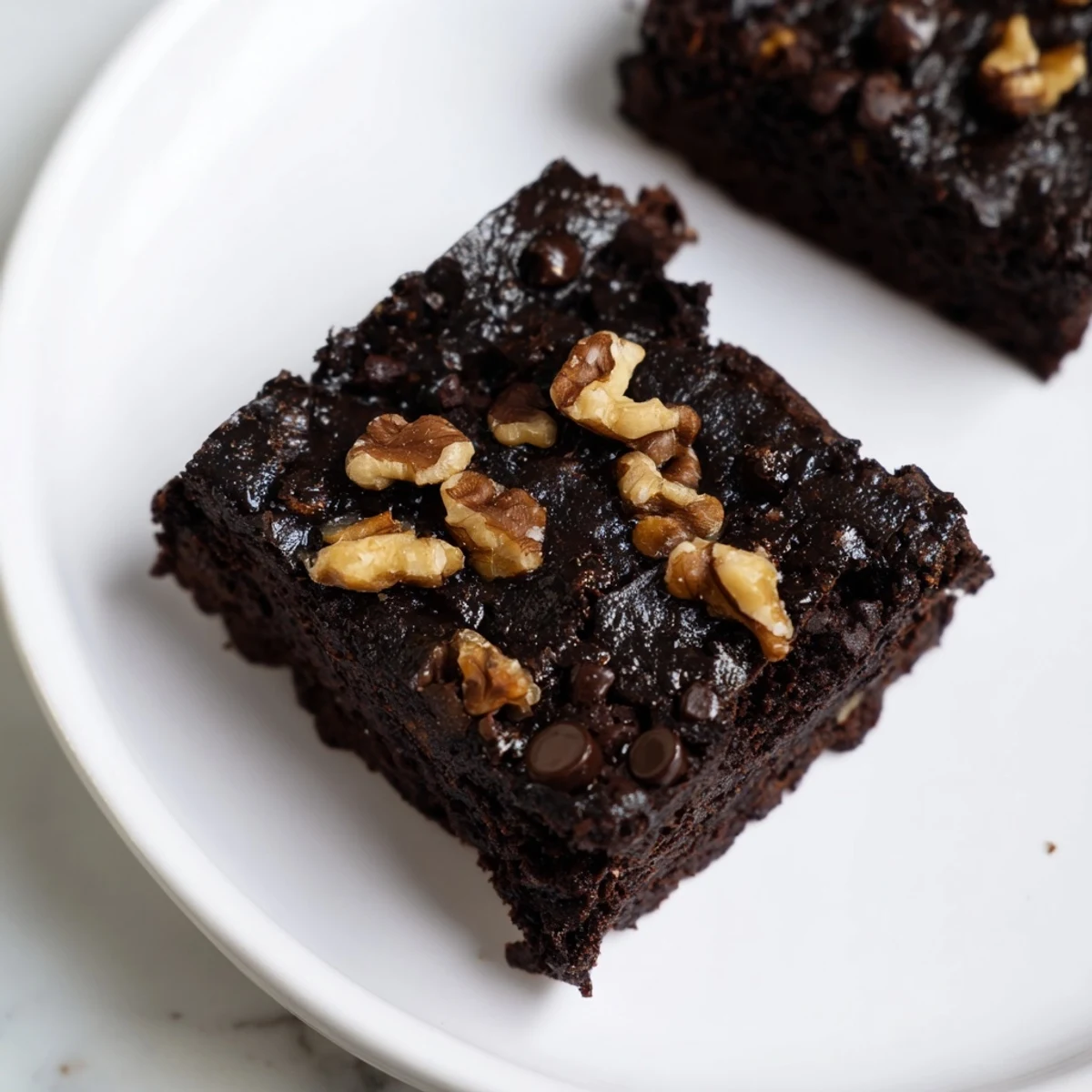 Rich, dark Black Bean Brownies are in a square pan, ready to be cut and served.
