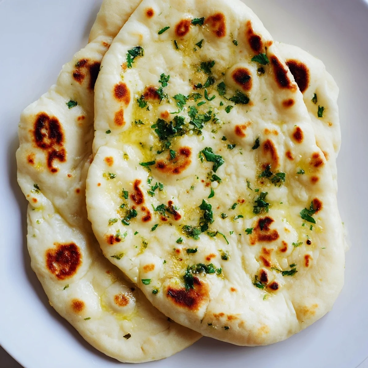 Fluffy homemade garlic naan bread brushed with garlic butter—a warm, savory Indian flatbread.