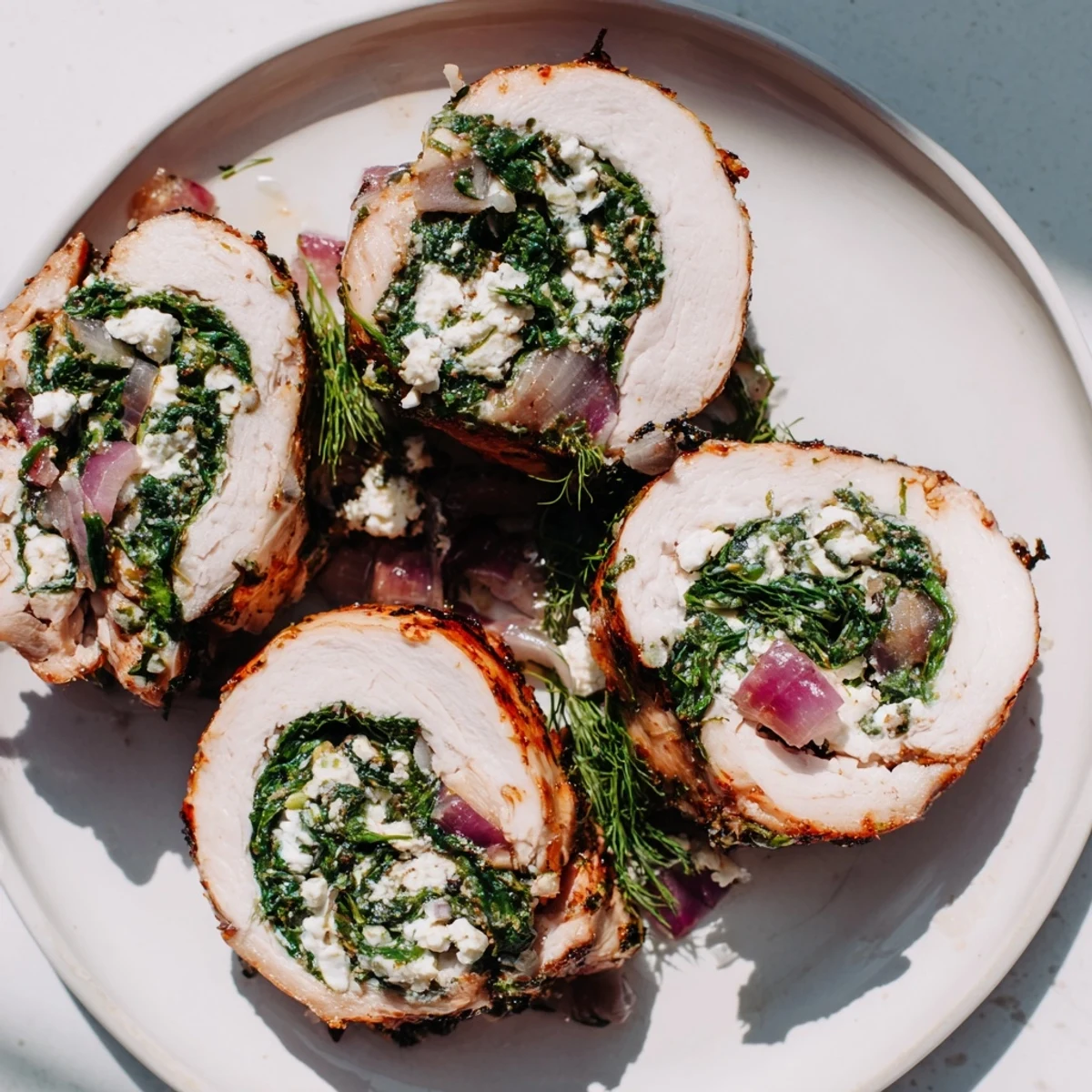 Close-up of baked Spinach Feta Stuffed Chicken, showing the creamy feta filling inside the juicy roll.