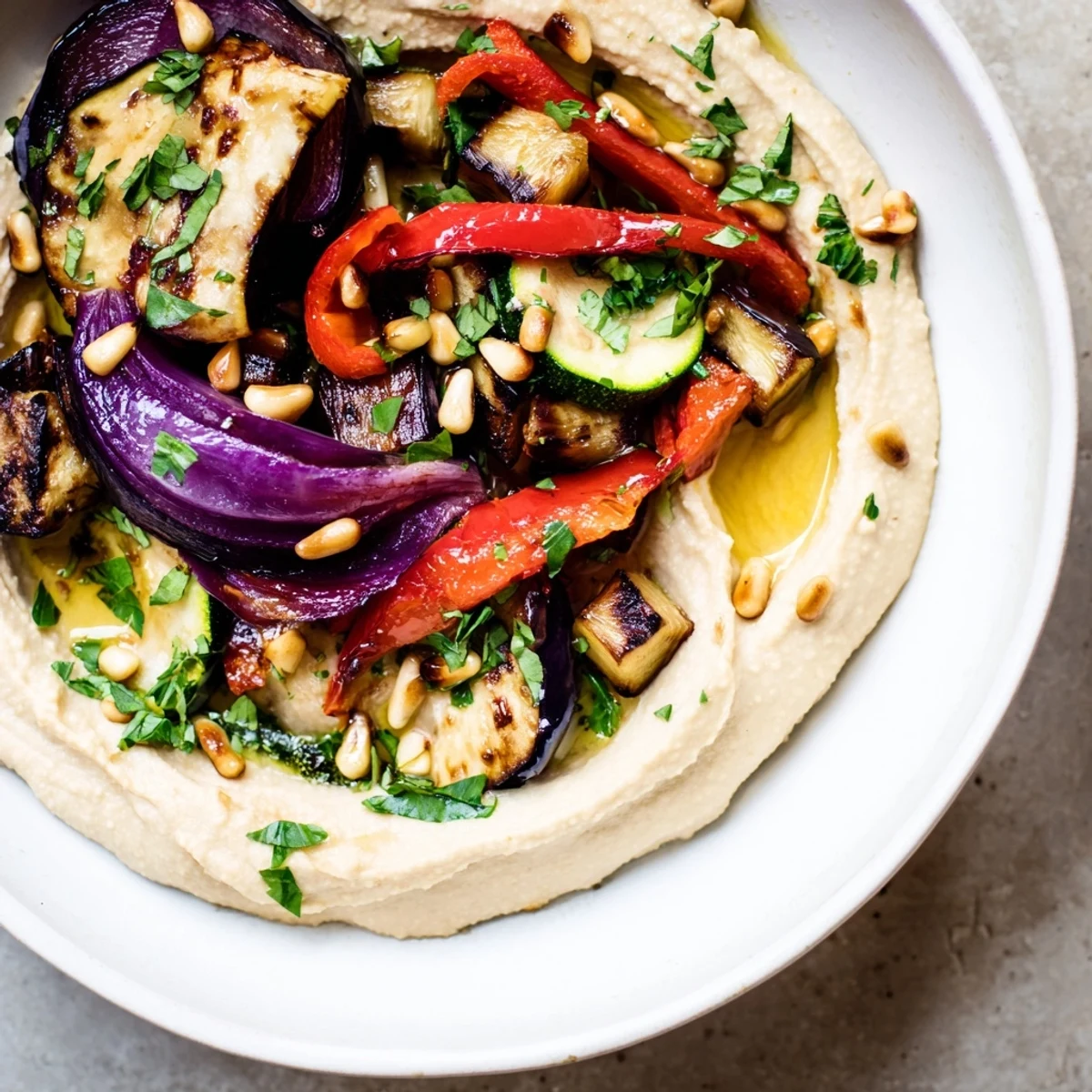 Beautifully plated Hummus Roasted Veggies showcase smoky, tender bell peppers, zucchini, and eggplant on a creamy hummus base.