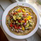 Golden, fluffy buckwheat pancakes alongside a vibrant pile of roasted vegetables, ready to eat.