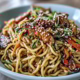 Wok-tossed Korean Turkey Fried Noodles, glazed in spicy gochujang sauce, topped with scallions and seeds.