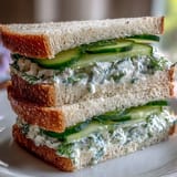 1. Cucumber Tea Sandwiches with Herbed Cream Cheese – zarte Gurkenscheiben und aromatisierter Frischkäse auf weichem Brot für einen erfrischenden Nachmittagstee.