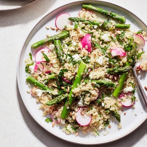 Frischer Asparagus- und Radieschen-Quinoa-Salat in einer bunten Schüssel angerichtet.