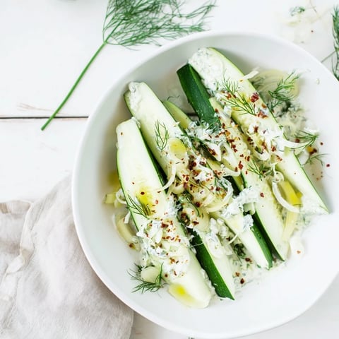 Crisp cucumbers in a vibrant Cold Cucumber-Dill Salad, glistening with creamy yogurt and fresh herbs.