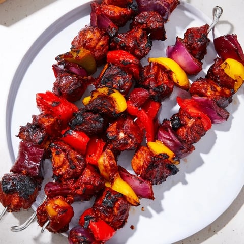 Glühwein-Marinated Chicken Skewers glistening from the grill with colorful bell peppers; a hearty main course.