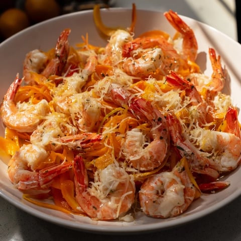 Vibrant Coral Reef dish featuring pink shrimp, citrus, and bubbling Gruyère cheese, a pescatarian delight.