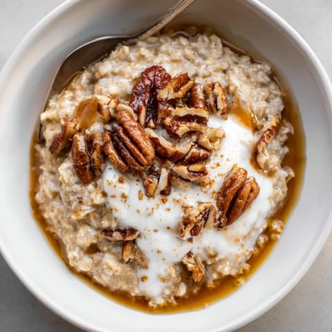 Warm, comforting bowl of pumpkin spice latte oats with a swirl of whipped cream and cinnamon.