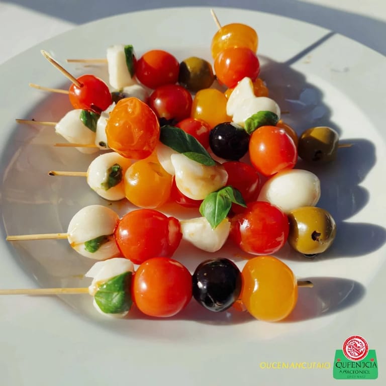 Fresh cherry tomatoes and olives artfully arranged as Christmas Lights Olive and Tomato Skewers for a colorful party.