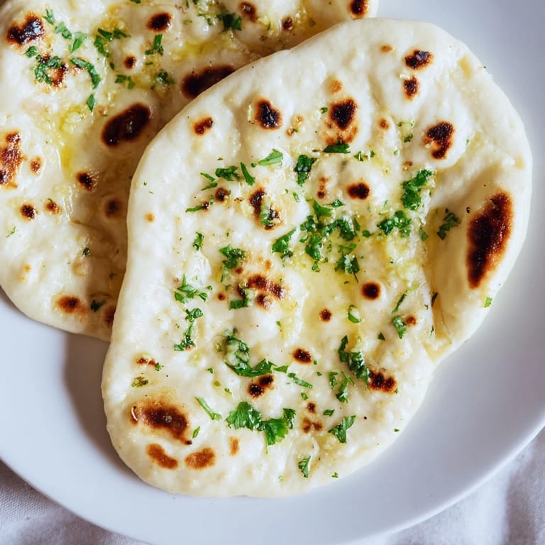 Golden brown garlic naan fresh from the skillet, ready to be served hot with your favorite curry.