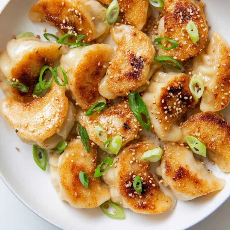 Close-up of perfectly cooked air fryer frozen dumplings, showcasing the sesame oil's rich flavor.