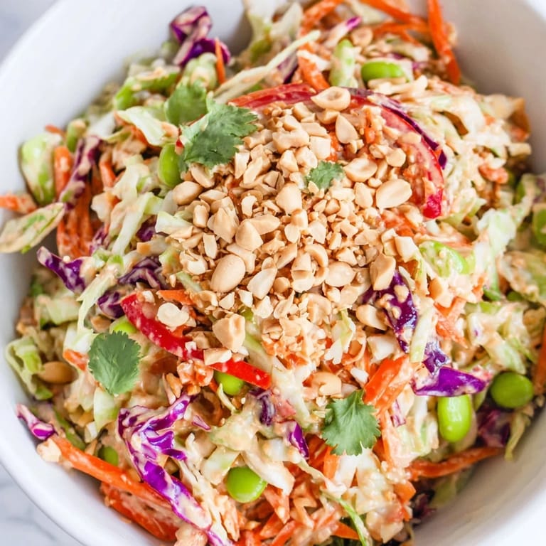Fresh Crunchy Thai Peanut Salad in a white bowl, featuring vibrant red bell pepper and green cilantro, ready to serve.