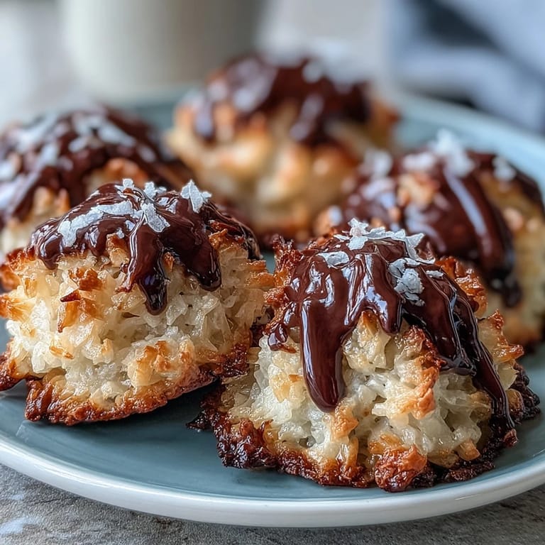 Saftige vegane Kokosmakronen mit reichhaltiger dunkler Schokoladenglasur, ideal für ein einfaches Dessert.